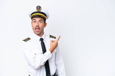 Airplane pilot over isolated white background surprised and pointing side