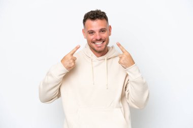 Beyaz arka planda izole edilmiş beyaz, beyaz, yakışıklı genç bir adam baş parmak işareti yapıyor.