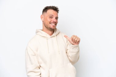 Beyaz arka planda soyutlanmış beyaz, yakışıklı, gururlu ve kendini beğenmiş genç bir adam.