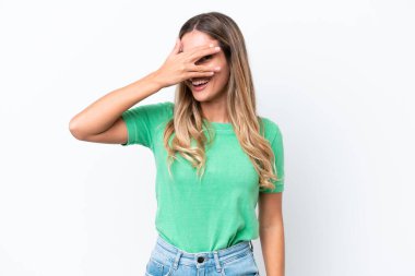 Young Uruguayan woman isolated on white background covering eyes by hands and smiling