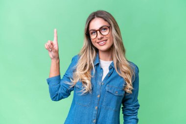 Genç Uruguaylı kadın izole edilmiş arka planda en iyinin işareti olarak parmağını kaldırıyor.
