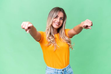 Genç Uruguaylı kadın izole edilmiş arka planda mutlu bir ifadeyle ön tarafı işaret ediyor