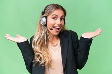 Tele pazarlamacı güzel Uruguaylı kadın izole bir arka planda çalışan şok olmuş yüz ifadesi olan bir kulaklıkla