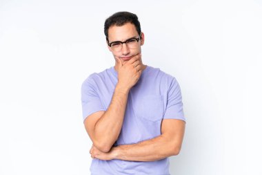 Beyaz arka planda soyutlanmış genç beyaz bir adamın şüpheleri var.