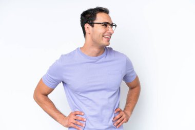 Beyaz arka planda izole genç beyaz adam kolları kalçasında poz ve gülümseme