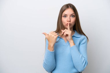 Genç Litvanyalı bir kadın beyaz arka planda izole edilmiş, kenarı işaret ediyor ve sessiz hareketler yapıyor.