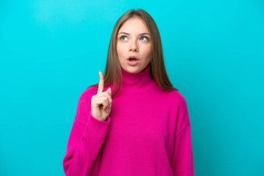 Genç Litvanyalı bir kadın mavi arka planda izole edilmiş.