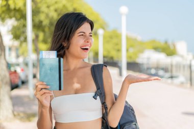 Genç, güzel bir Bulgar kadın, elinde sürpriz bir yüz ifadesiyle dışarıda bir pasaport tutuyor.