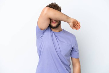 Beyaz arka planda izole edilmiş yakışıklı beyaz adam gözleri elleriyle kapatıyor.