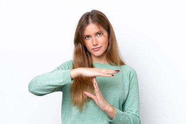 Beyaz arka planda izole edilmiş genç beyaz bir kadın zaman aşımı hareketi yapıyor.