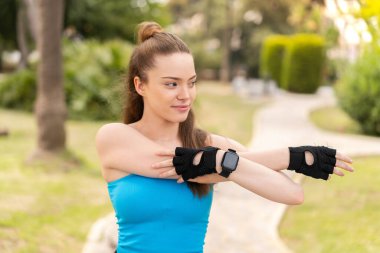 Dışarıda spor yapan ve esneme hareketleri yapan güzel bir kız.