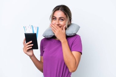 Şişirilebilir Seyahat Yastığı ile genç ve güzel Uruguaylı kadın beyaz arka planda izole edilmiş mutlu ve ağzı kapalı gülümsüyor.