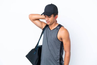 Spor çantalı beyaz tenli genç bir adam beyaz arka planda, boyun ağrısı ile izole edilmiş.