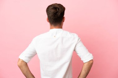 Pembe arka planda izole edilmiş beyaz, yakışıklı genç bir adam.