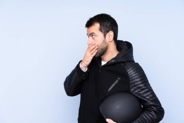 İzole edilmiş arka planda motosiklet kasklı bir adam elleriyle ağzını kapatıyor.