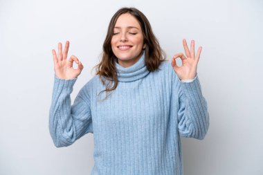 Beyaz arka planda Zen pozisyonunda beyaz tenli genç bir kadın.