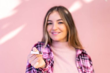 Genç ve güzel Romen kadın dışarıda kredi kartı tutuyor