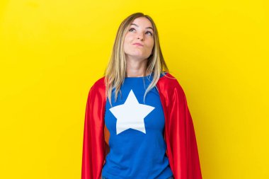 Süper kahraman Romen kadın sarı arka planda izole edilmiş ve yukarı bakıyor