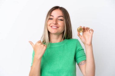 Beyaz arka planda izole edilmiş Bitcoin taşıyan genç Romen kadın, bir ürünü sunmak için kenarı işaret ediyor