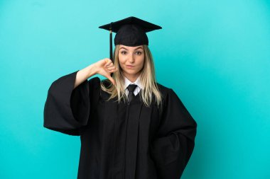 Tecrit edilmiş mavi arka planda genç üniversite mezunu.