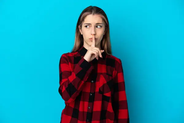 年轻的高加索女人 在蓝色的背景上被隔离 表现出沉默的姿态 用手指捂住嘴 — 图库照片