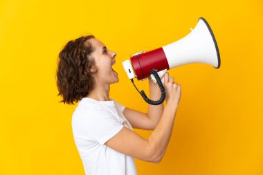 Sarı arka planda izole edilmiş genç bir İngiliz kadın megafondan bir şey duyurmak için bağırıyor.