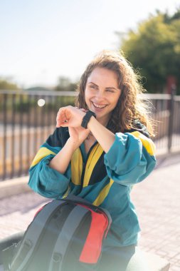 Sırt çantası ve saati olan bir kadın.