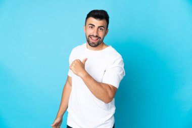 Kafkasyalı erkek soyutlanmış mavi arka plan gururlu ve kendini beğenmiş.