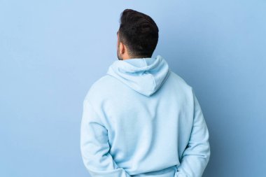 Kafkas adam izole edilmiş mavi arka planda ve geriye bakıyor