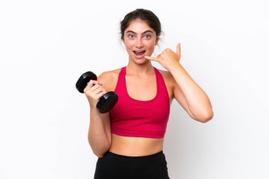 Beyaz arka planda halter kaldıran beyaz saçlı genç bir kadın telefon jesti yapıyor. Bana geri dönüş işareti ver.