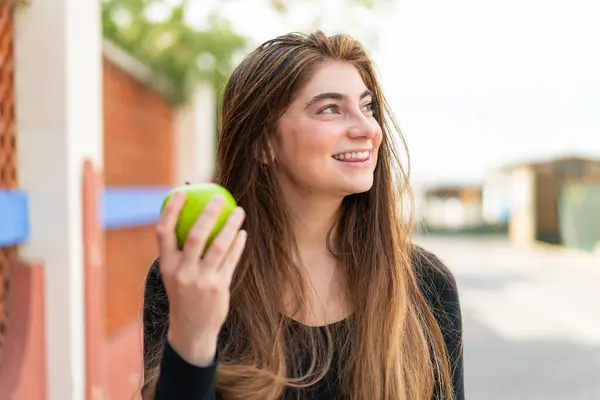 Młoda Ładna Biały Kobieta Jabłko Zewnątrz Patrząc Górę Uśmiechając Się — Zdjęcie stockowe