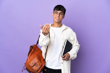 İzole edilmiş mor arka planda genç bir öğrenci, bizimle gelmesi için davet ediyor. Gelmene sevindim.