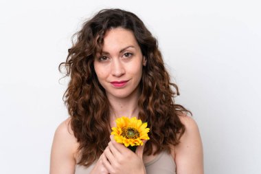 Beyaz arka planda izole edilmiş beyaz bir kadın elinde bir ayçiçeği tutuyor. Portreyi kapat