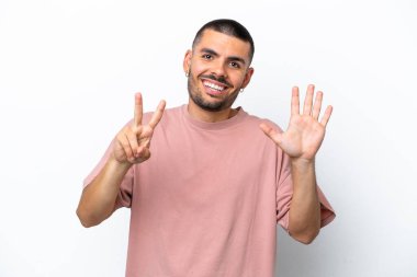 Beyaz arka planda izole edilmiş genç beyaz adam yediyi parmaklarıyla sayıyor