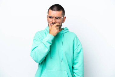 Beyaz arka planda izole edilmiş genç beyaz bir adam. Şüpheleri var ve kafası karışmış bir yüz ifadesi var.