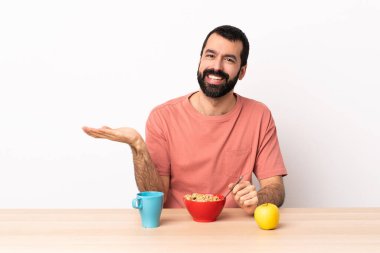 Kafkasyalı bir adam bir masada kahvaltı yapıyor. Elinde bir ilan vermek için fotokopi makinesi var..