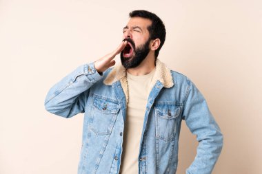 İzole edilmiş arka planda sakallı, esneyen ve ağzı açık olan beyaz bir adam.