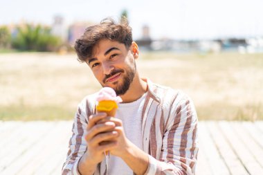 Açık havada kornet dondurmalı yakışıklı bir Arap.