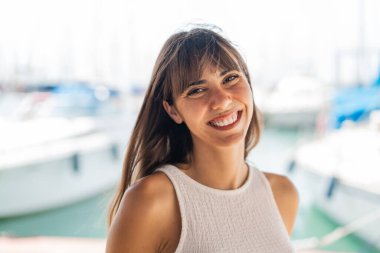 Açık havada genç bir kadın Neşeli bir ifadeyle