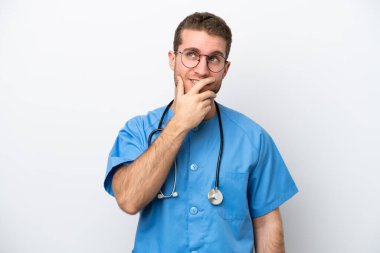 Genç cerrah beyaz arka planda izole edilmiş beyaz bir adam. Şüpheleri var ve kafası karışmış bir yüz ifadesi var.