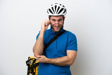 Beyaz arka planda gözlüklü ve mutlu, termal sırt çantalı beyaz bir adam.