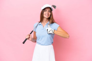 Young golfer player man isolated on pink background giving a thumbs up gesture