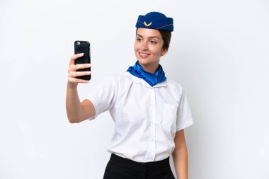 Uçak hostesi beyaz arka planda izole edilmiş beyaz bir kadın selfie çekiyor.