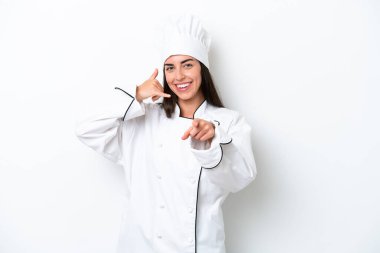 Beyaz arka planda genç bir aşçı kadın telefon jesti yapıp ön tarafı işaret ediyor.