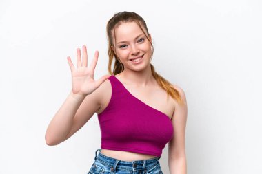 Beyaz arka planda izole edilmiş genç beyaz kız parmaklarıyla beşi sayıyor.