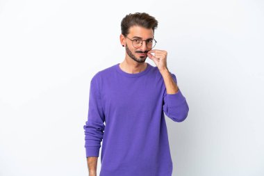 Beyaz arka planda izole edilmiş genç beyaz bir adam sessizlik işareti gösteriyor.