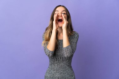 Genç Romen kadın mor arka planda izole edilmiş bağırıyor ve bir şey duyuruyor