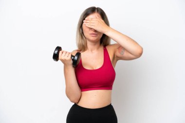 Genç Romen spor kadını halter kaldırıyor. Beyaz arka planda izole edilmiş, gözleri elleriyle kapatıyor. Bir şey görmek istemiyorum.