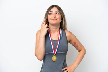 Beyaz arka planda madalyaları olan genç Romen kadın şans diliyor ve en iyisini diliyor.