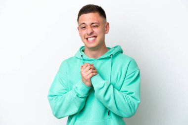 Genç Brezilyalı adam beyaz arka planda izole edilmiş gülüyor.